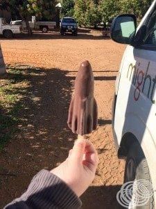 Chocolate coated frozen mango on a stick