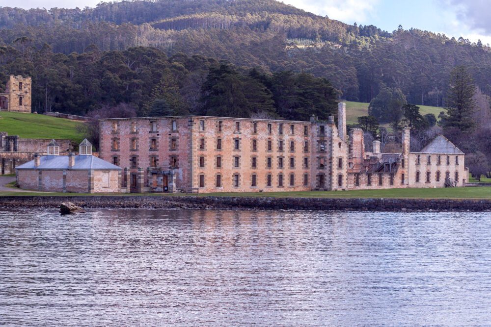 The ruins of Port Arthur convict settlement with water from the harbour in the foreground